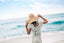 Frau mit Strandhut am Meer